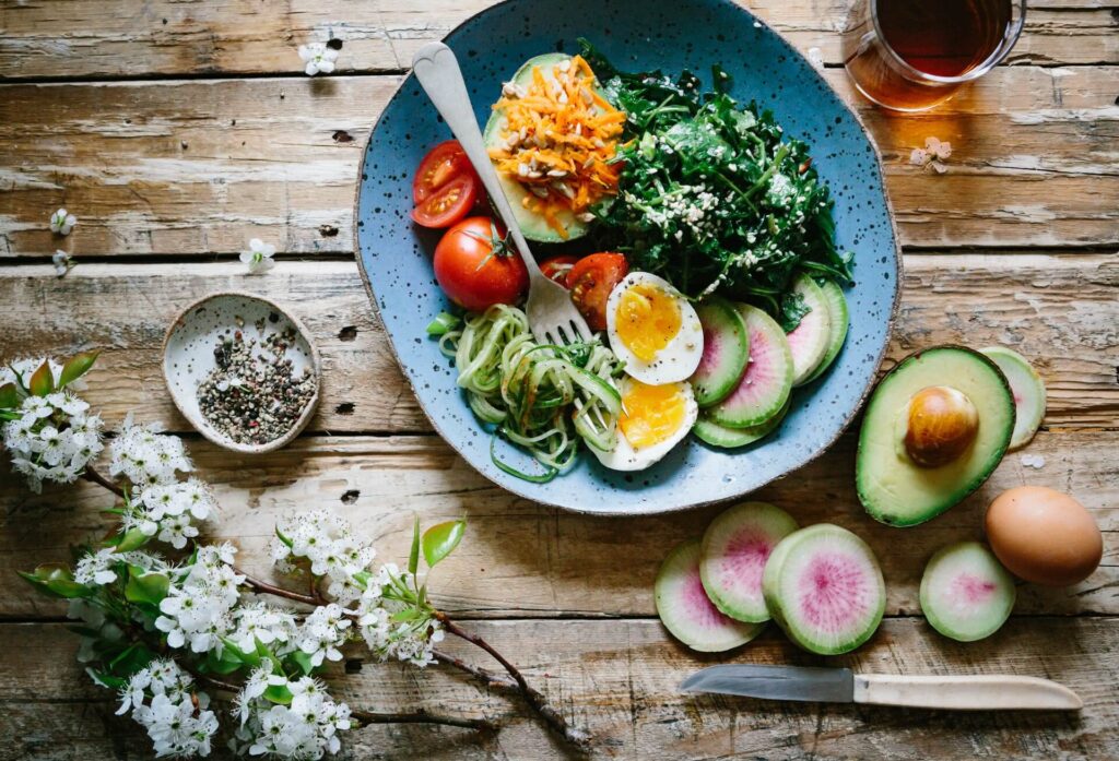 Healthy food on wooden table with knife and flowers