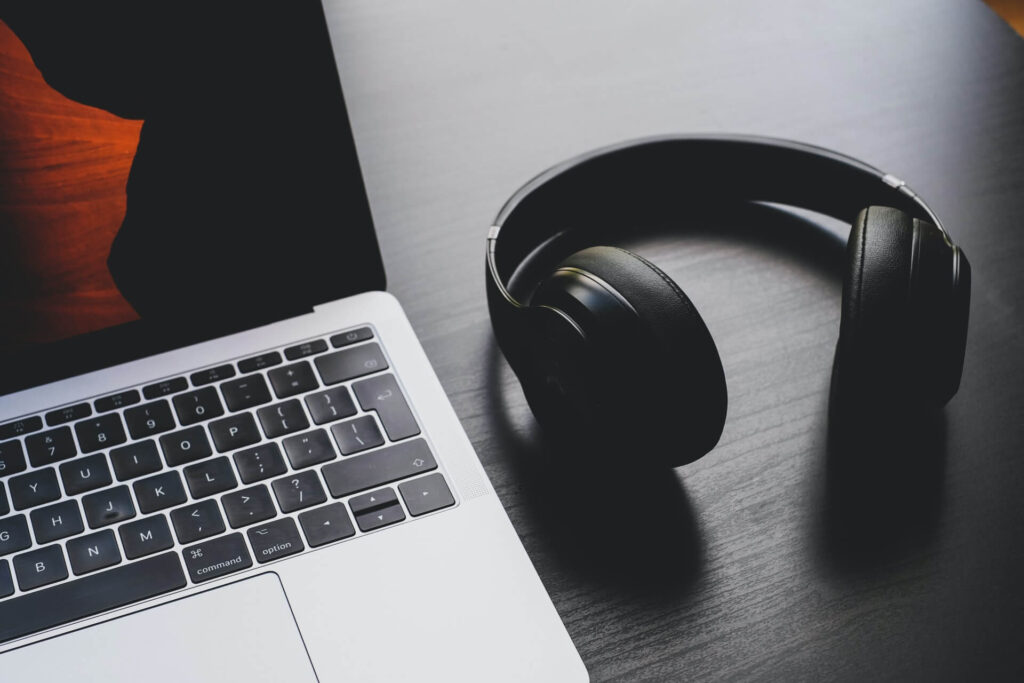Headphones and laptop on a desk.