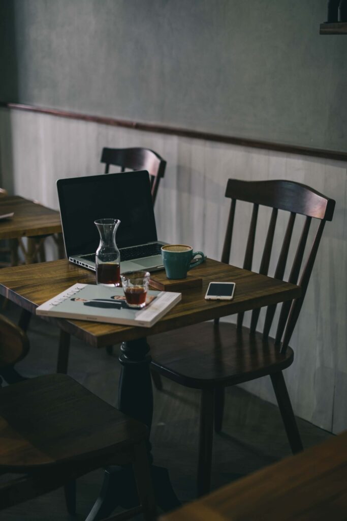 Latop Coffee and Phone at Coffee Shop wher you can go to overcome loneliness when working from home
