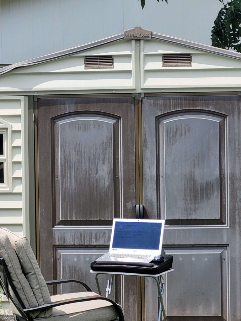 Laptop on a Foldable Desk with chair outside shed office