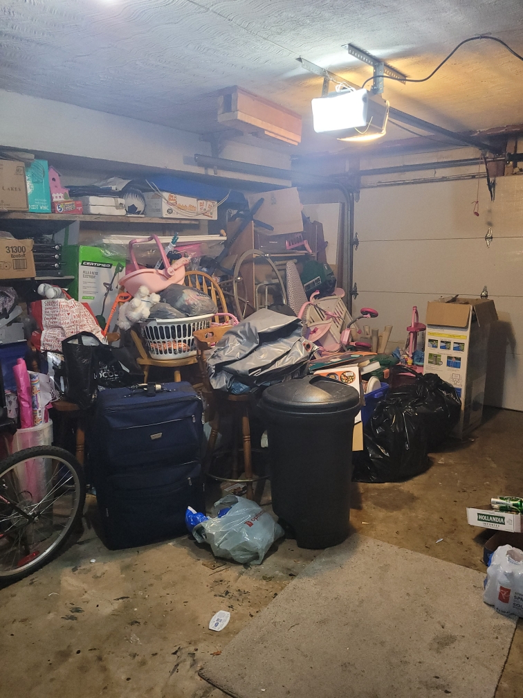 Messy garage in the middle of being decluttered for a garage office.