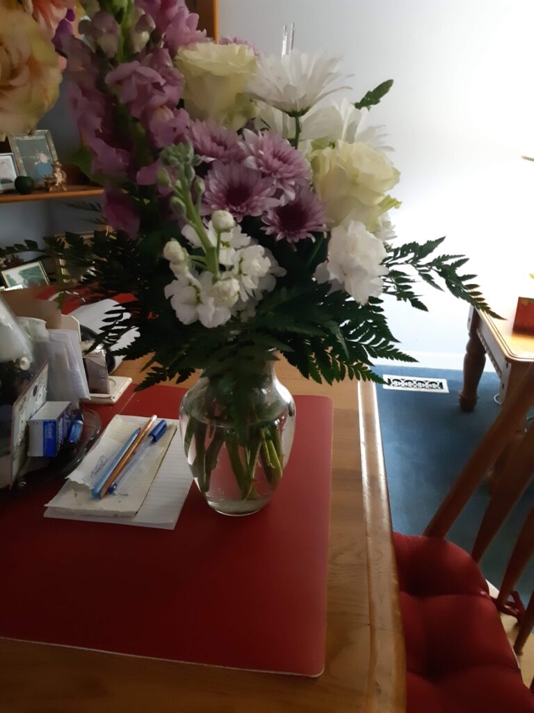 Flowers on a table with office supplies in background