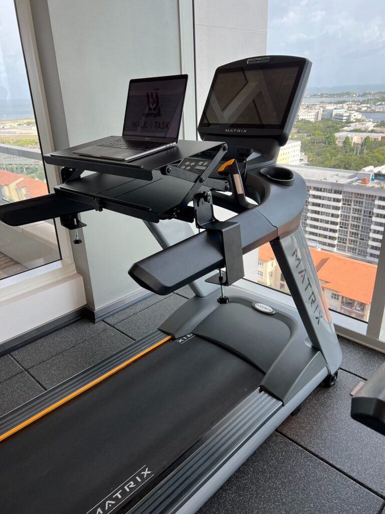 A Walk-i-Task desktop attachment on a matrix treadmill in a highrise room with windows on both sides