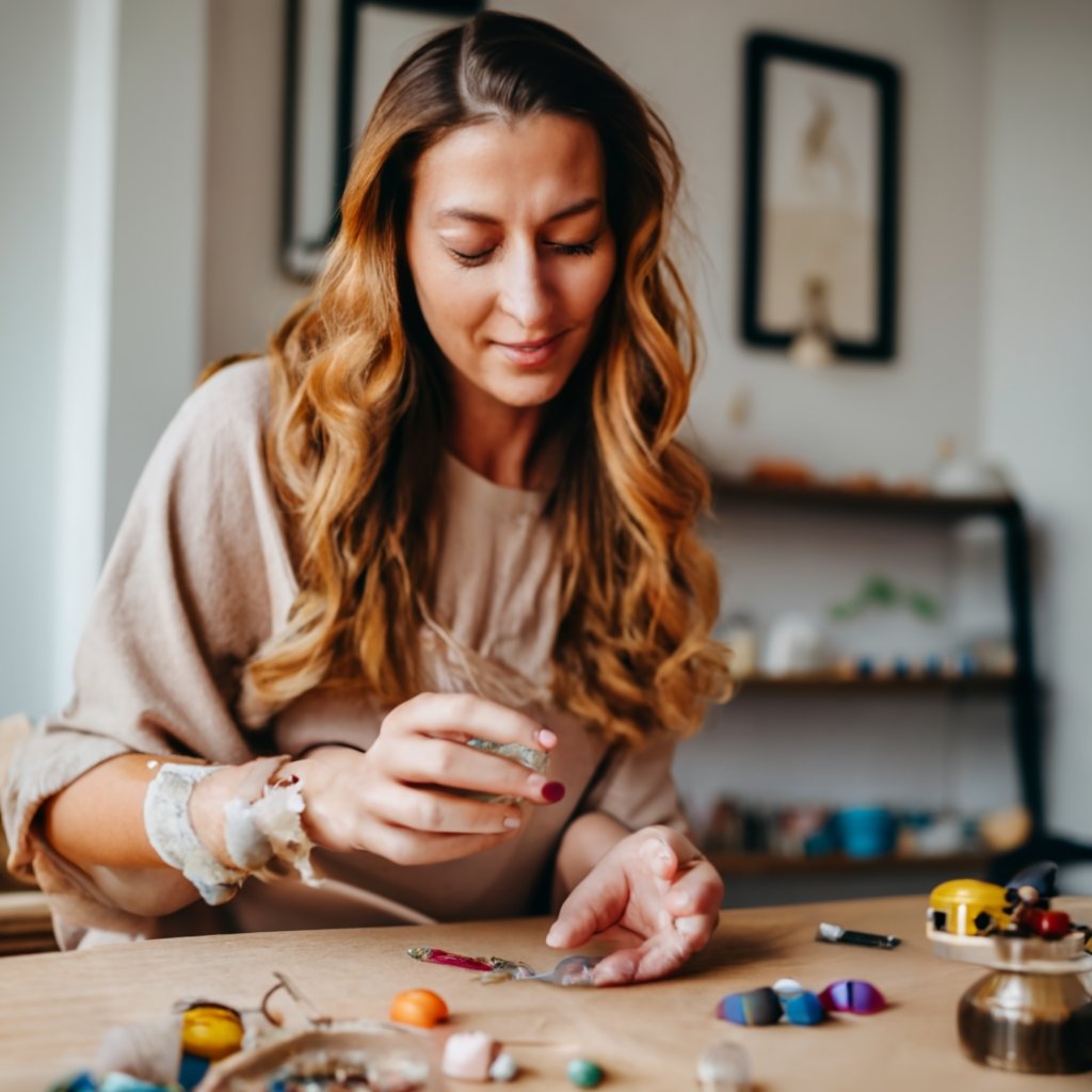 Image of a woman worling on homemade jewelry as an example of one of the craft business ideas in the list.