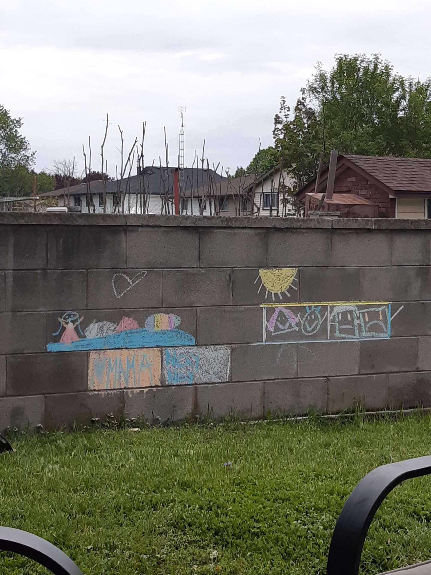 An image of kids chalk drawings on a brick wall outdoors as an example for outdoor painting classes number 70 on our list of backyard business ideas
