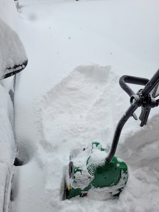 Snow removal as an example of one of the more profitable winter business ideas. The picture shows an electric snow shovel in waste deep snow.